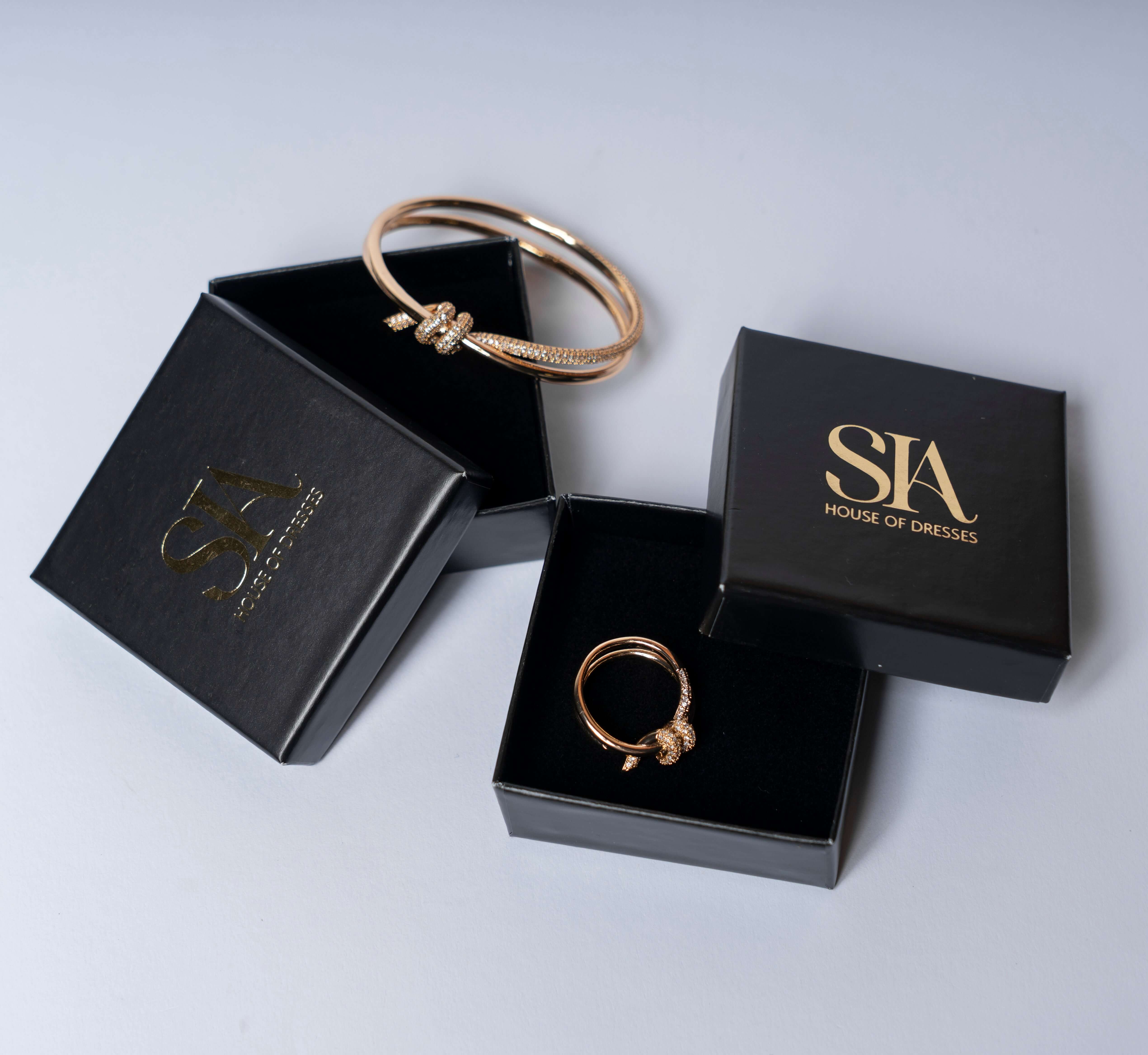 Set bratara si inel cu nod si cristale SIA in cutie eleganta, rose gold, simbol al legaturilor speciale si stilului sofisticat.