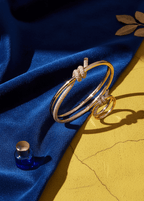 Set brățară și inel cu nod și cristale SIA Knot Crystal Set auriu, cu cristale strălucitoare, pe fundal albastru