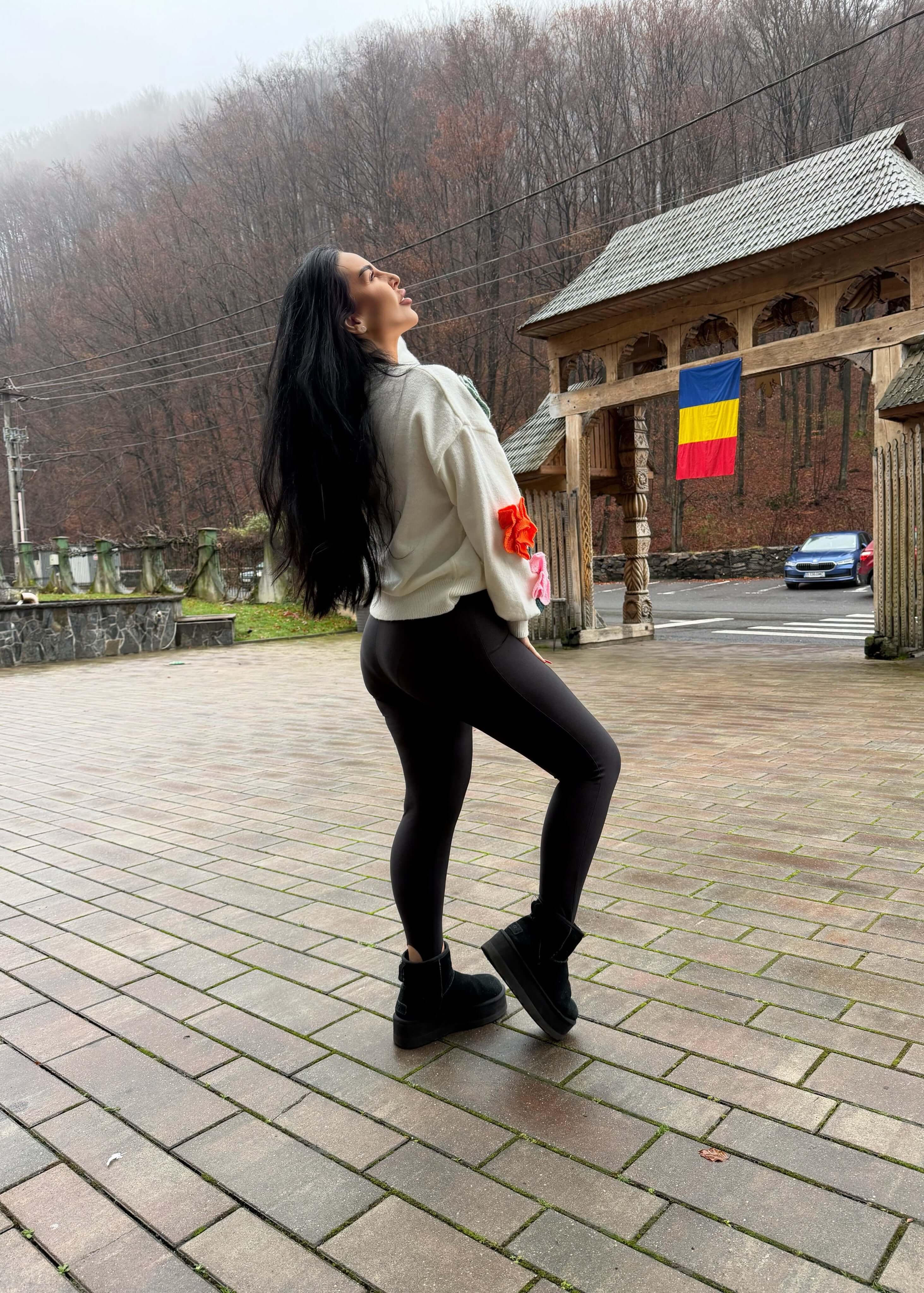 Femeie purtând Colanti modelatori lycra premium FANCY SIA, ținută casual neagră, în aer liber, lângă foișor tradițional românesc