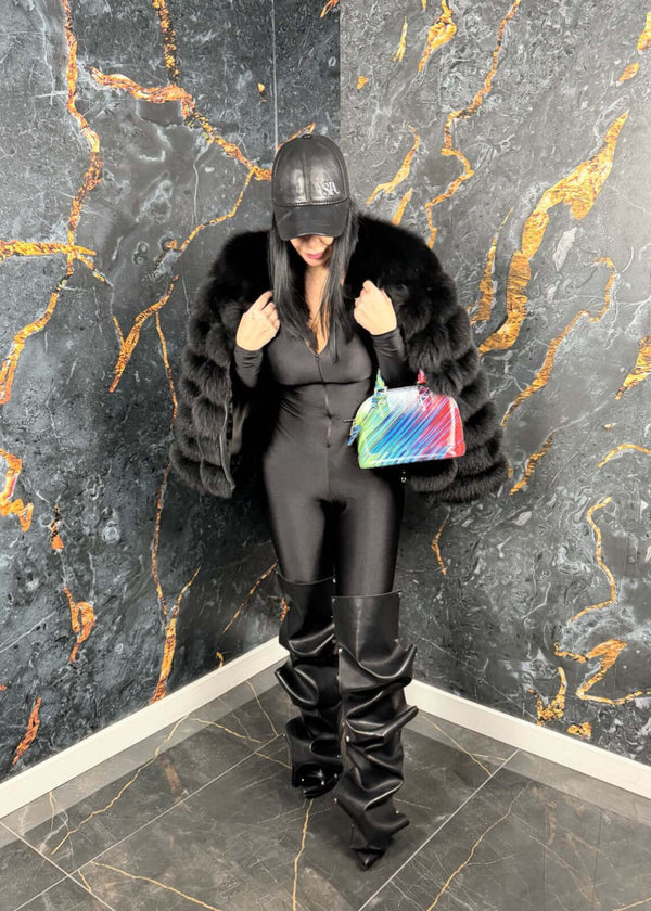 Femeie în Sia Salopeta modelatoare Venom, outfit negru elegant, pardesiu din blană și geantă colorată, ținută modernă cu atitudine.