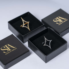 Inel statement stea dubla cu cristale auriu și argintiu, prezentat în cutie elegantă, accesorii glam și moderne.
