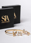 Set SIA Butterfly Dream, brățară aurie cu fluturi și cristale, bijuterie elegantă lângă cutii negre SIA House of Dresses