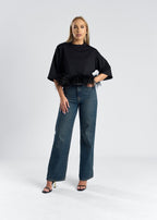 Tricou mini oversized cu detalii din pene, o piesă stilată, purtată cu jeansi negri