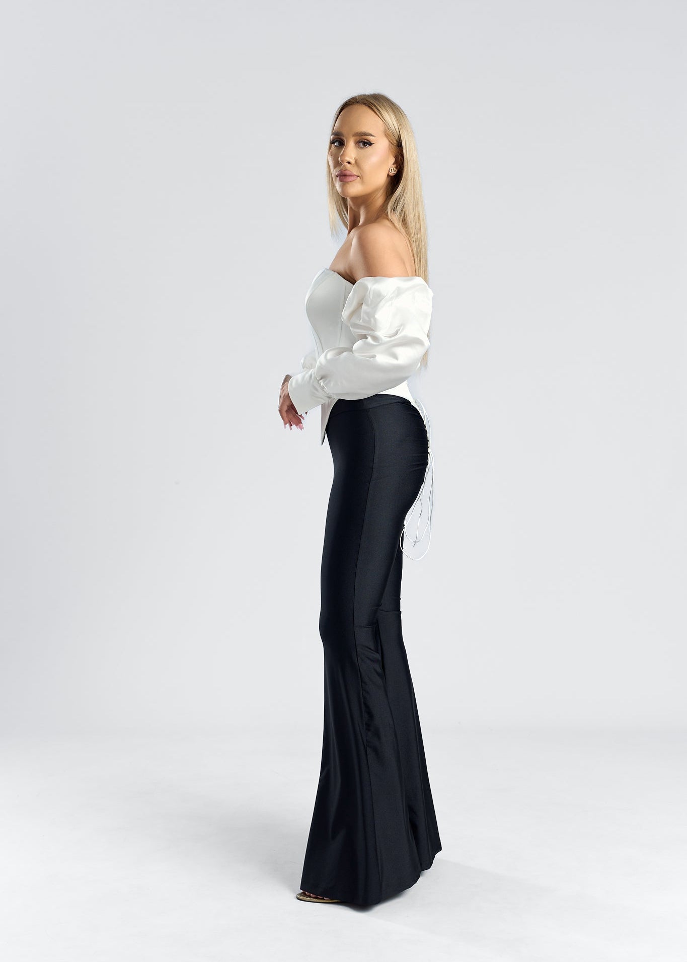 model purtand un corset tafta cu maneci ÉLYSEE alături de pantaloni negri.