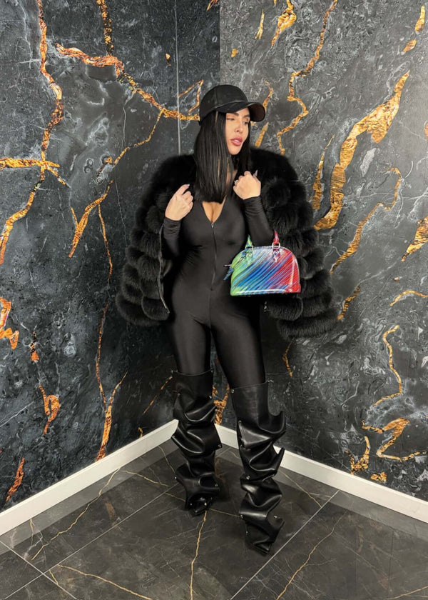 Femeie purtând SIA Venom jumpsuit, salopeta modelatoare neagră, cu fermoar, accesorii elegante, pantaloni lungi și geantă colorată.