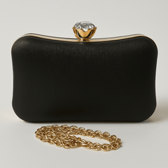 Geantă clutch neagră elegantă cu textură discretă, închizătoare de diamant și lanț auriu detașabil. Ideală pentru evenimente rafinate.