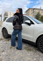 Geaca WINTER ARMOR cu guler îmblănit detașabil, matlasată, impermeabilă și rezistentă la vânt, purtată lângă un SUV alb