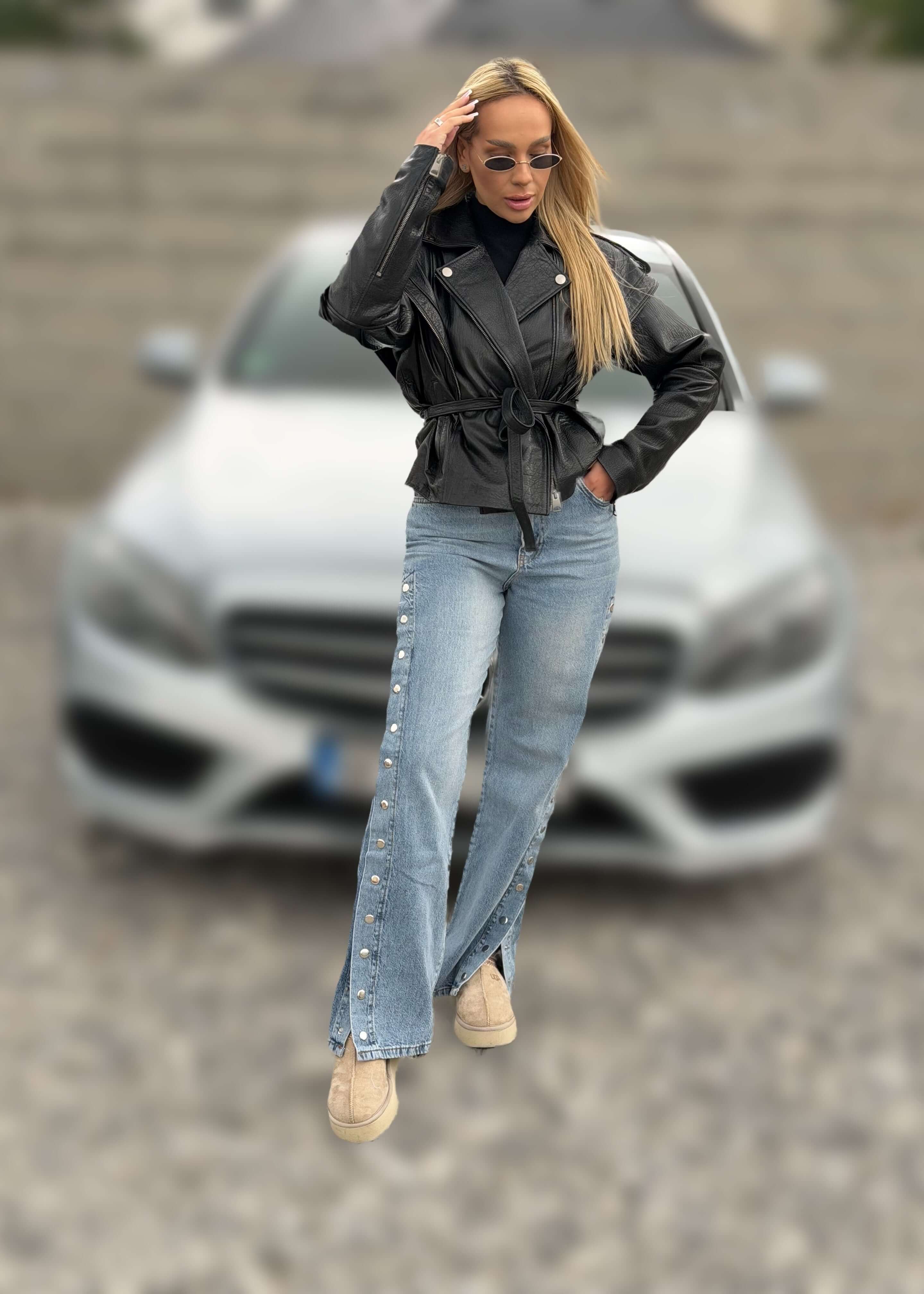 Blugi cu capse laterale SNAP ME, outfit urban cu jachetă din piele neagră în fața unei mașini