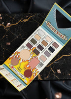 Paleta The Balm Balm Jovi Rockstar Face Palette deschisă, nuanțe de farduri și blush pe fundal marmură neagră