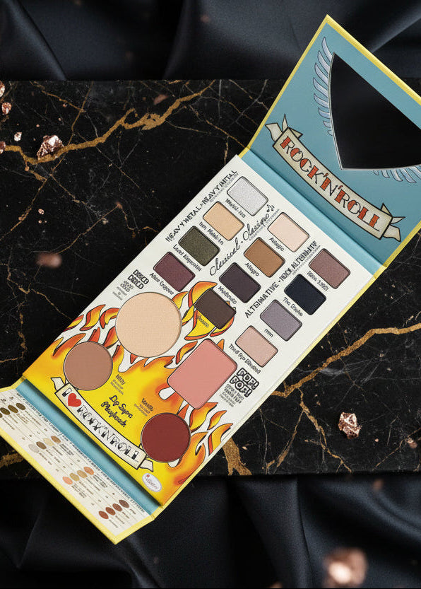 Paleta The Balm Balm Jovi Rockstar Face Palette deschisă, nuanțe de farduri și blush pe fundal marmură neagră