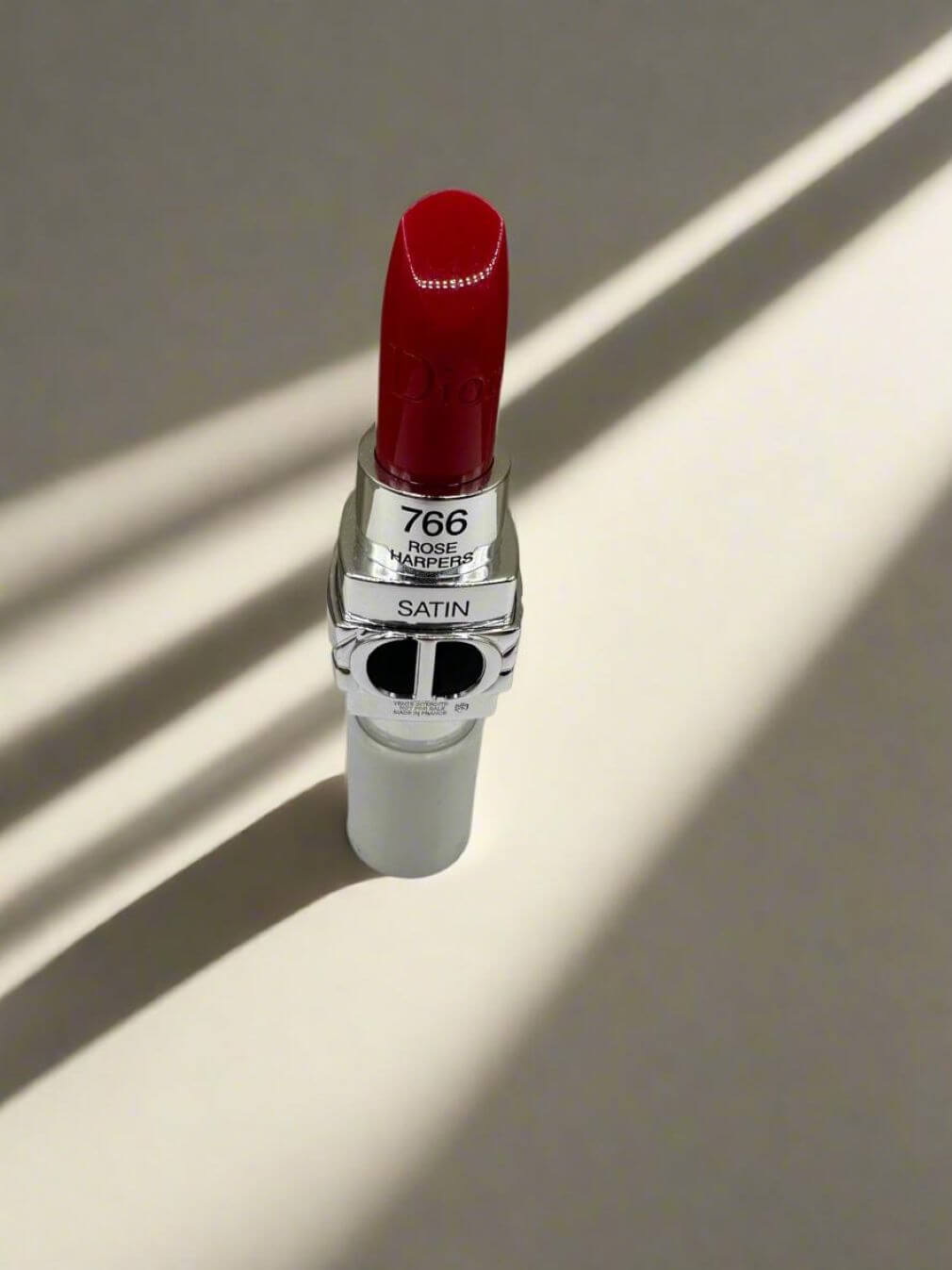 Ruj Dior Rouge Dior, nuanța 766 Satin, cu ambalaj elegant și design sofisticat, iluminat artistic.