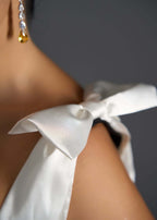 Rochie elegantă cu fundă din satin ivoire pe umăr și cercei statement, detaliu rafinat pentru Rochie de ocazie