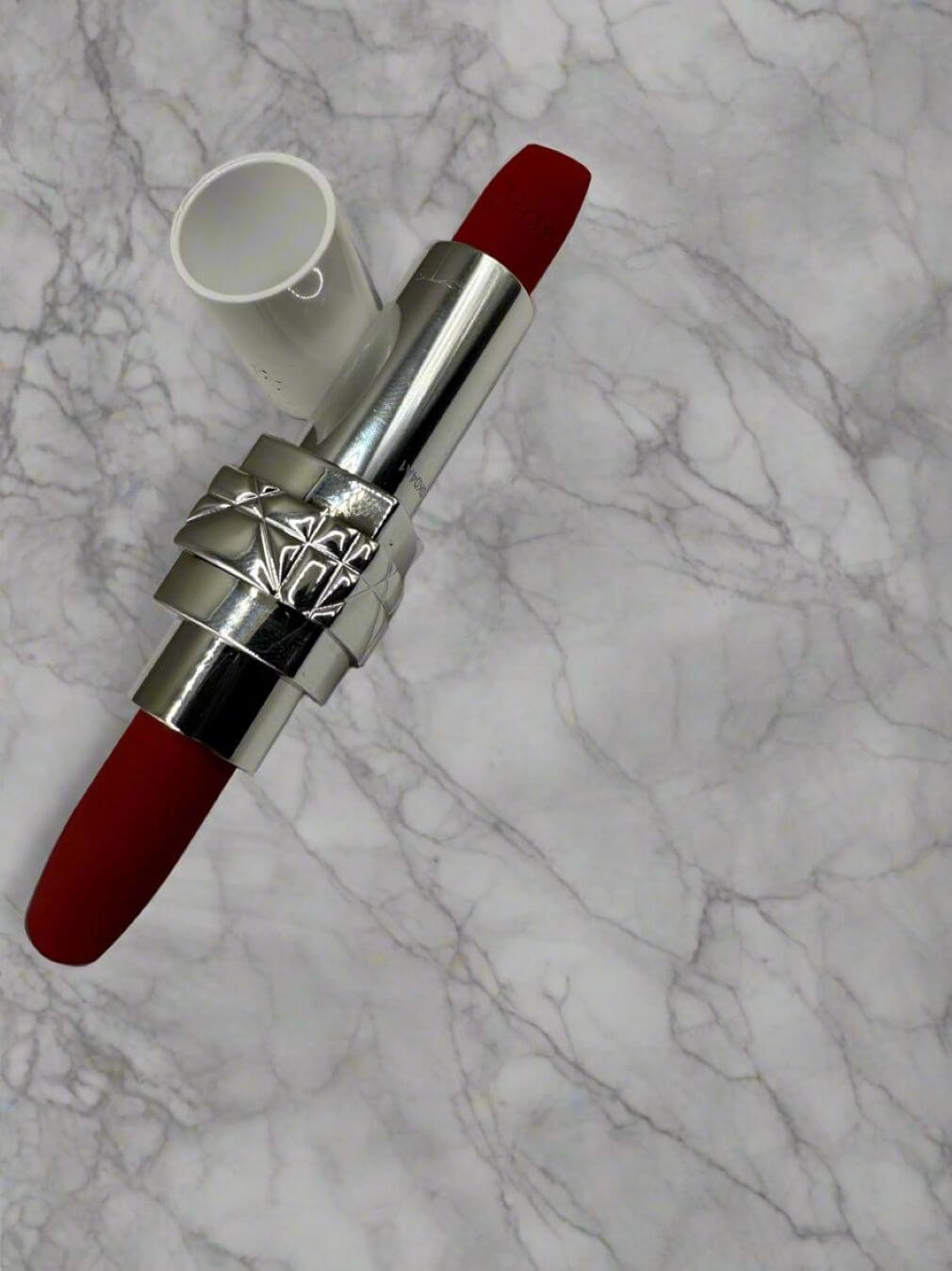 Ruj Dior Rouge Dior pe marmură, design sofisticat, culoare roșie vibrantă, ideal pentru trusa de beauty modernă.